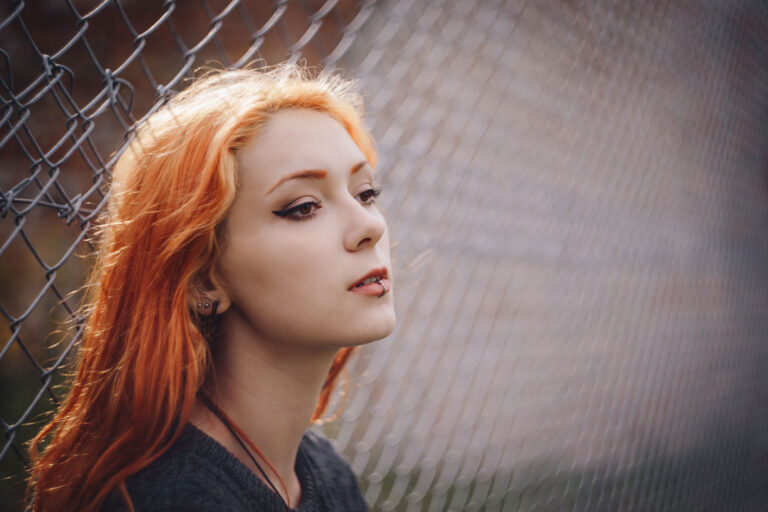 girl_leaning_against_a_net_fence